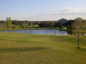 open acre pond surrounded by sunny manicured meadows